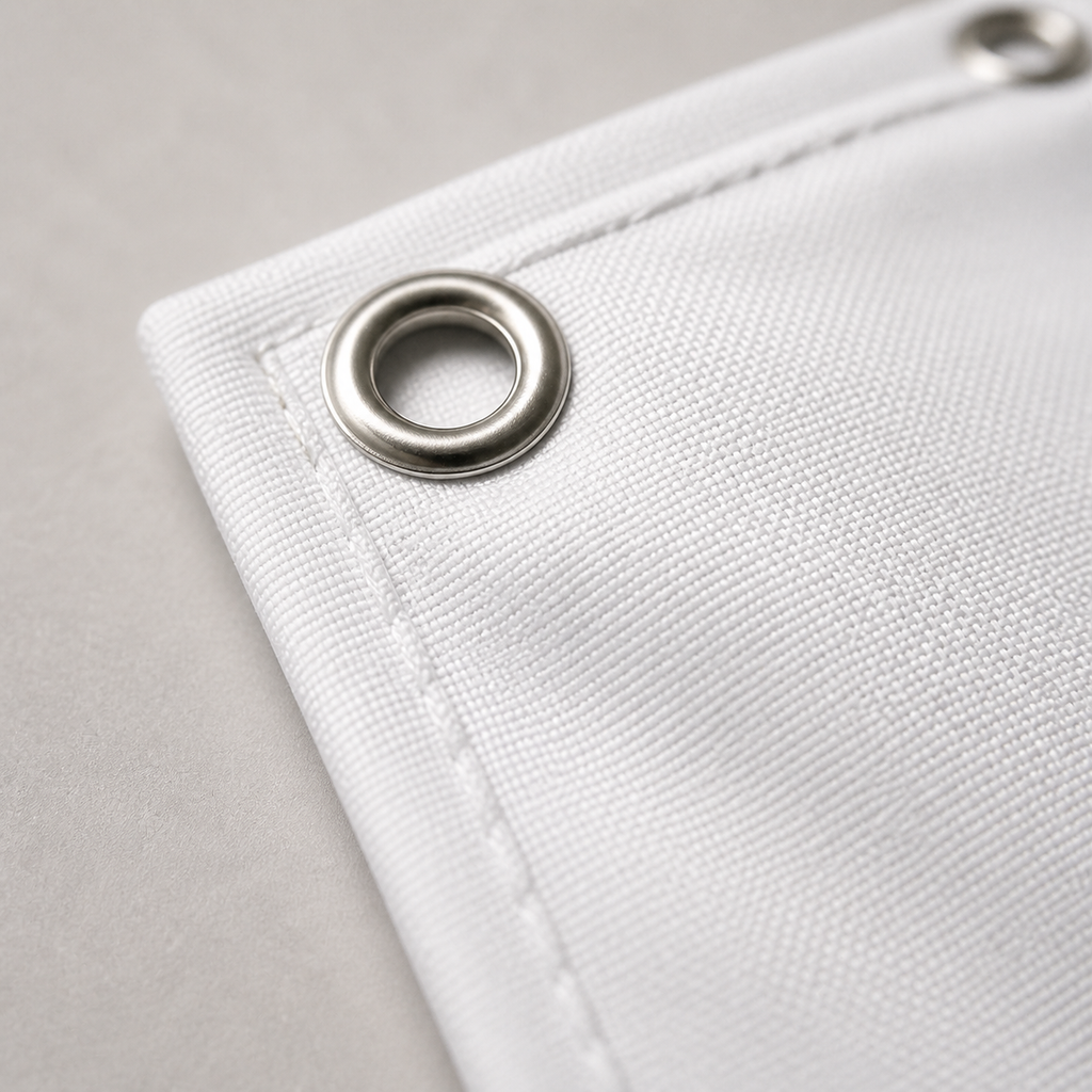 Close-up of white hem and reinforced metal grommet
