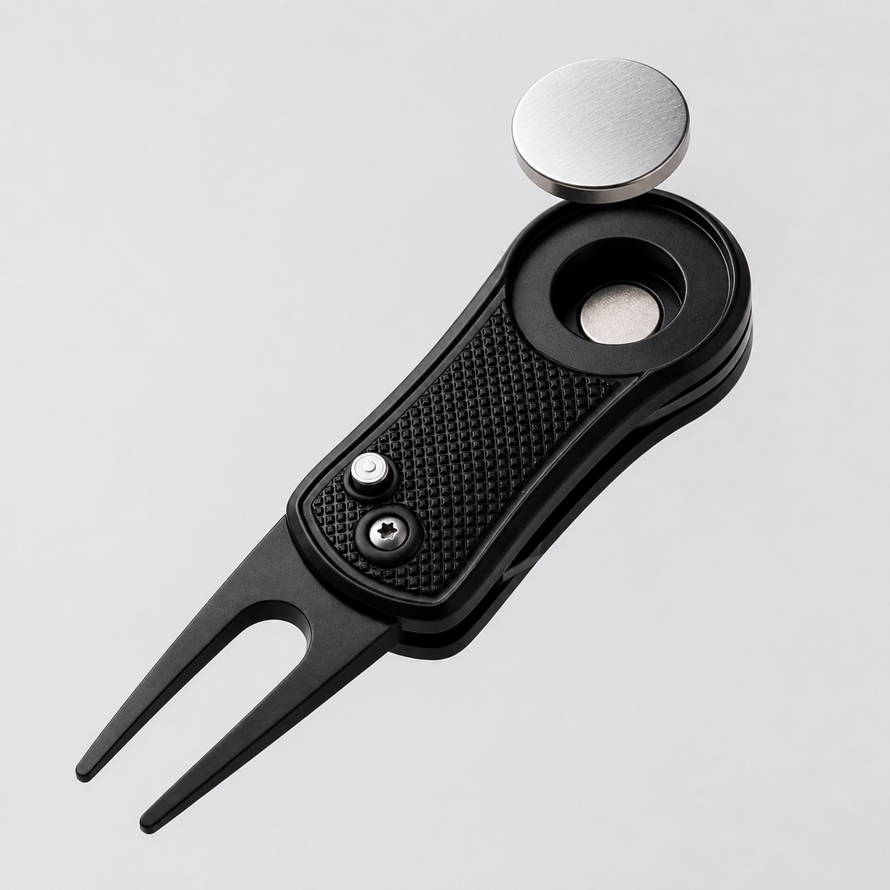 Removable magnetic ball marker lifted above black divot repair tool